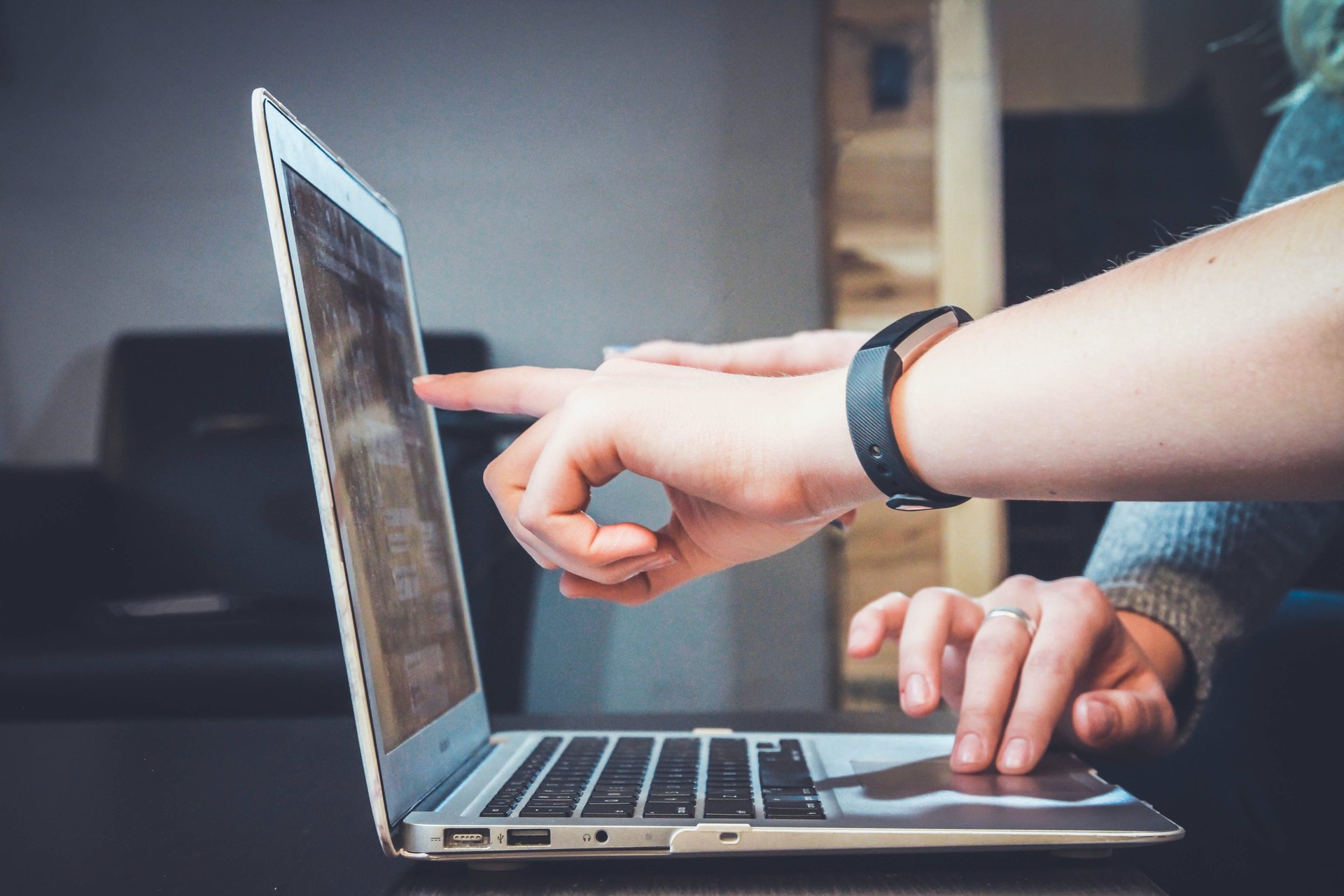 Hands pointing at the screen showing how will design impact the growth of a business.