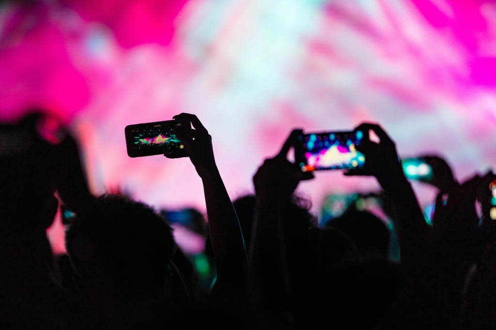 a group of people holding their phones during a live concert