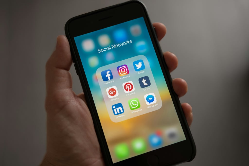 a hand holding a cell phone with social media apps