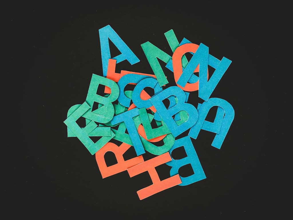 a salad of various colorful letters on a black background